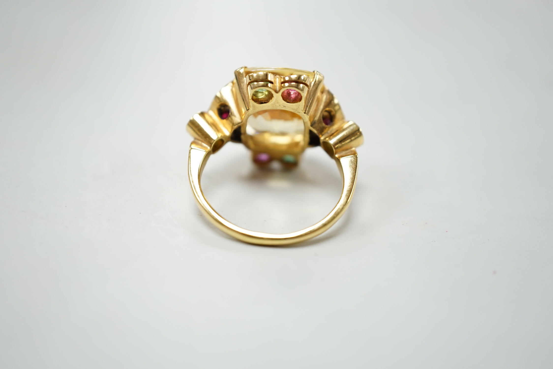 An 18ct and single stone yellow sapphire set dress ring, with emerald and ruby set setting and shoulders, size M, gross weight 9.4 grams.